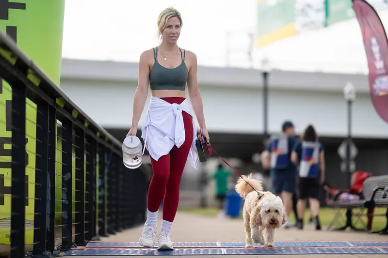 Participante de evento de run club caminhando com um cachorro após a prova